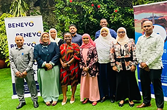 A BENEVO training cohort standing in front of BENEVO banners